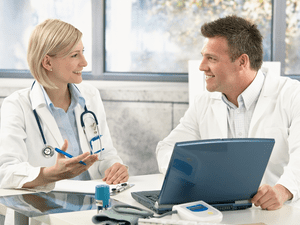 doctors smiling with papers and laptop