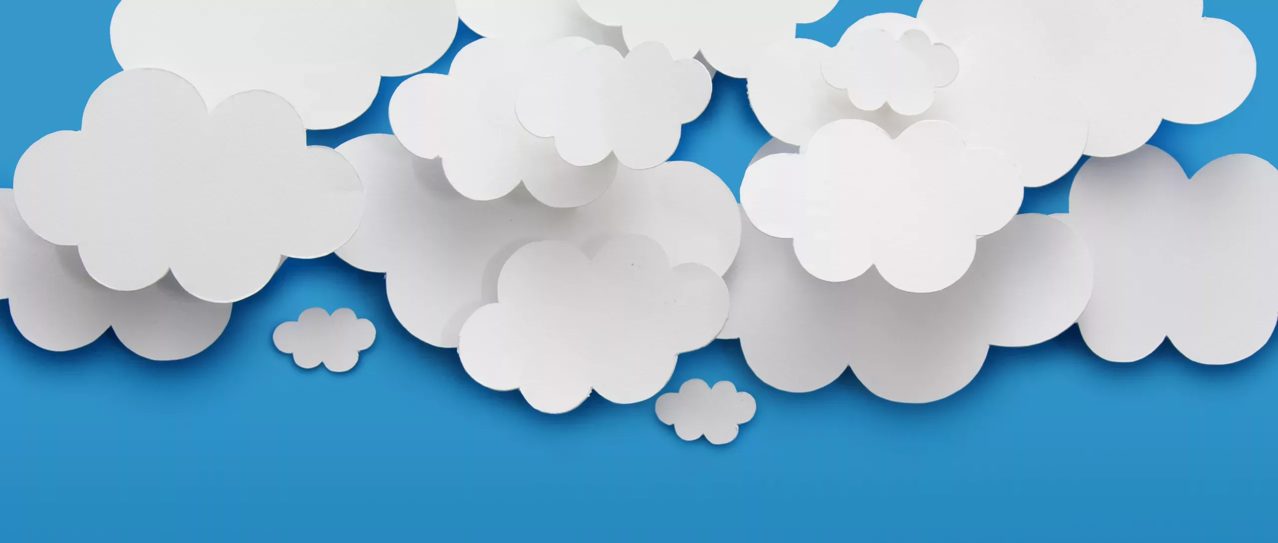 Paper cutouts of clouds on a blue background